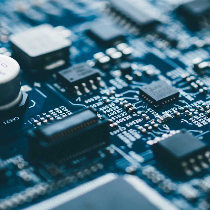 Close-up of a blue printed circuit board with electronic components.